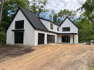25955 Wild Rose Ln, Shorewood, MN 55331 - view of front of home featuring driveway and an attached garage
