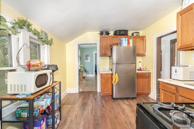 560 Stryker Ave, Saint Paul, MN 55107 - kitchen featuring freestanding refrigerator, brown cabinetry, dark wood-type flooring, white microwave, and range with gas stovetop