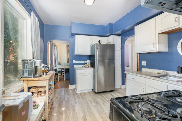 560 Stryker Ave, Saint Paul, MN 55107 - kitchen featuring a sink, freestanding refrigerator, black range with gas cooktop, and arched walkways