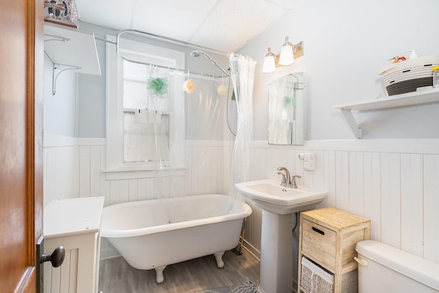 560 Stryker Ave, Saint Paul, MN 55107 - full bath featuring a shower with curtain, toilet, a wainscoted wall, a tub, and wood finished floors