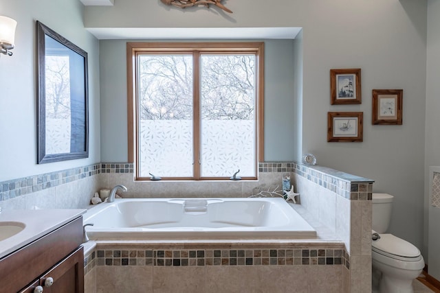 bathroom with vanity, toilet, and a bath