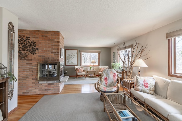 30 Interlachen Ln, Tonka Bay, MN 55331 - living room featuring a brick fireplace, healthy amount of natural light, light wood finished floors, and a textured ceiling