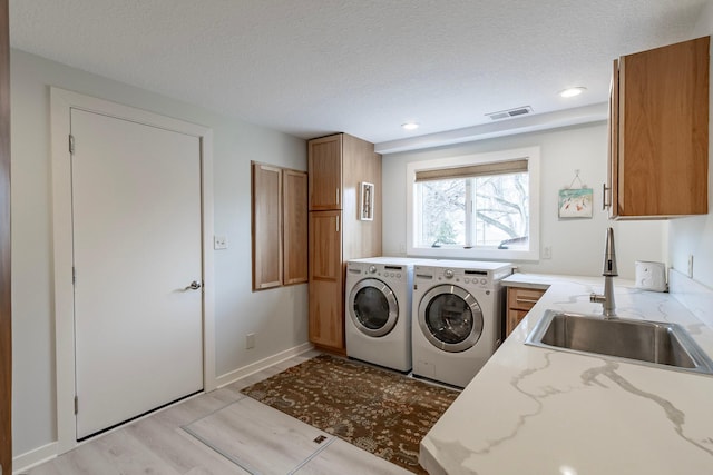 30 Interlachen Ln, Tonka Bay, MN 55331 - laundry room featuring washing machine and dryer, cabinet space, light wood finished floors, a textured ceiling, and recessed lighting