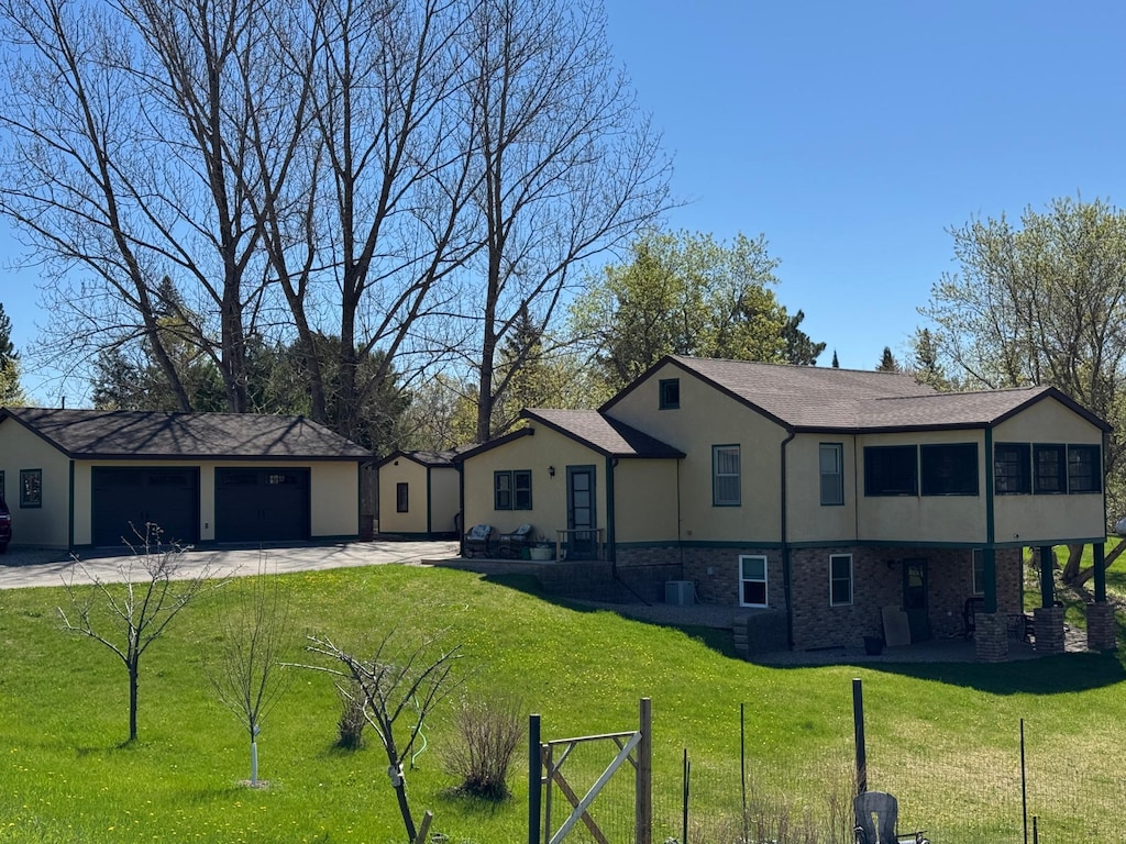 view of front facade featuring stucco siding, a front lawn, concrete driveway, and a garage