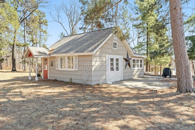 view of side of property featuring a shingled roof