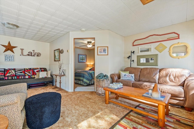 living area featuring carpet floors and a ceiling fan