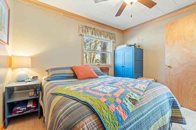 bedroom with crown molding, ceiling fan, and wood finished floors