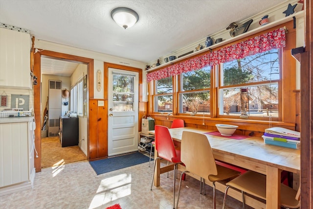 dining room featuring light flooring and a textured ceiling