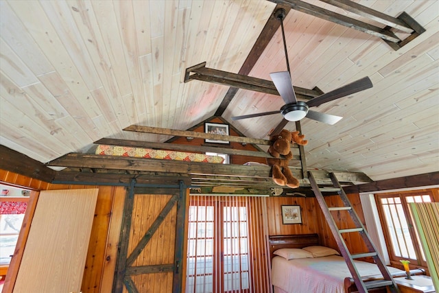 detailed view of wood ceiling, beam ceiling, wooden walls, and a ceiling fan