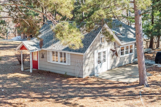 exterior space featuring roof with shingles