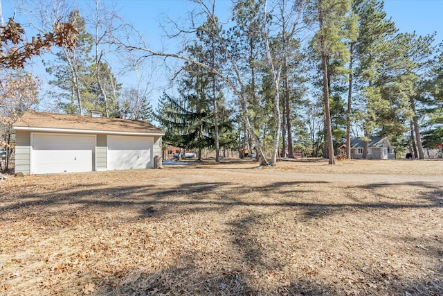 view of yard featuring an outdoor structure and a detached garage