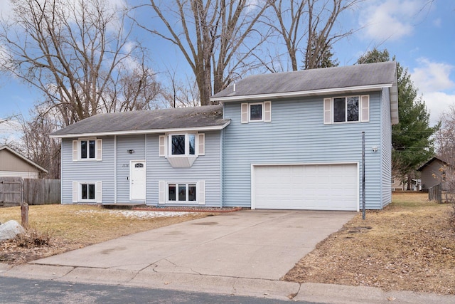 view of front facade featuring driveway, an attached garage, and fence
