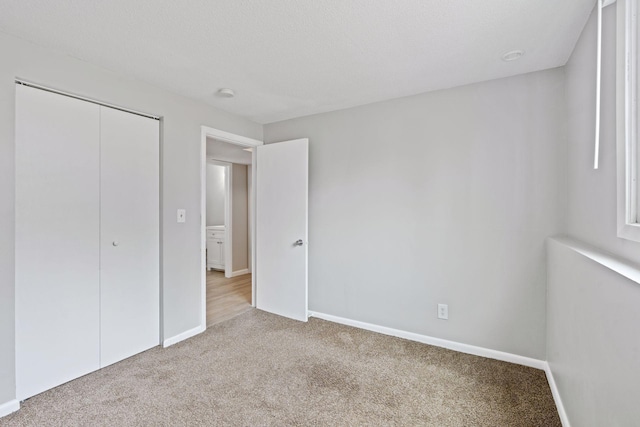 unfurnished bedroom with baseboards, a closet, and carpet