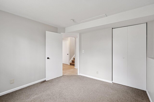 unfurnished bedroom featuring baseboards, a closet, and carpet flooring