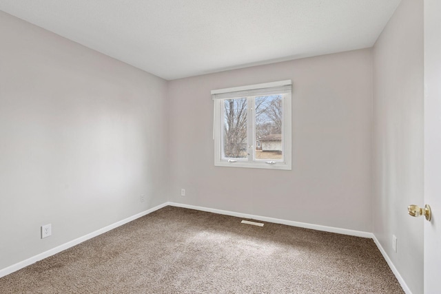 unfurnished room featuring baseboards, visible vents, and carpet flooring