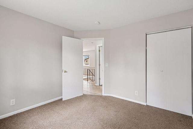 unfurnished bedroom featuring baseboards, a closet, and carpet flooring