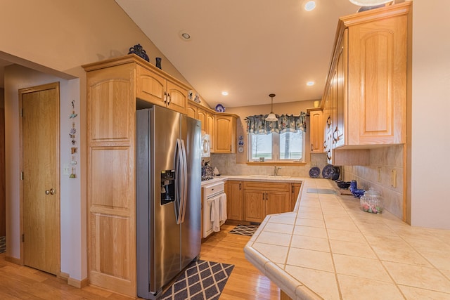 48987 Tamarac Dr, Scambler Twp, MN 56572 - kitchen featuring light wood-style flooring, a sink, stainless steel fridge, decorative backsplash, and tile countertops