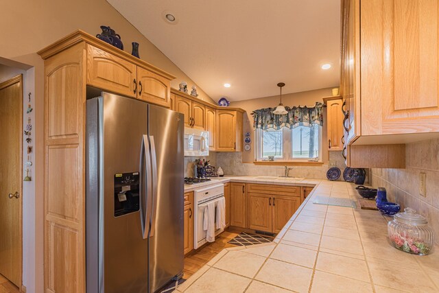 48987 Tamarac Dr, Scambler Twp, MN 56572 - kitchen with lofted ceiling, tile countertops, a sink, white appliances, and tasteful backsplash