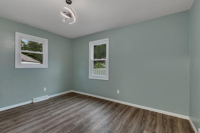 257 Elm Dr, Foley, MN 56329 - unfurnished room featuring healthy amount of natural light, dark wood finished floors, and a textured ceiling