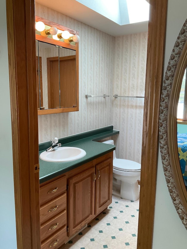 14289 Memorywood Dr, Baxter, MN 56425 - bathroom with vanity, toilet, wallpapered walls, and tile patterned floors