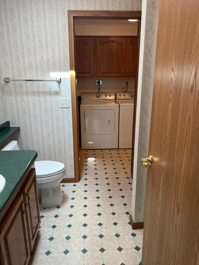 14289 Memorywood Dr, Baxter, MN 56425 - half bathroom with washing machine and clothes dryer, wallpapered walls, tile patterned floors, toilet, and vanity