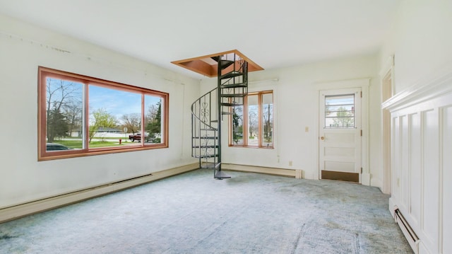 unfurnished room with carpet, a baseboard heating unit, and stairs