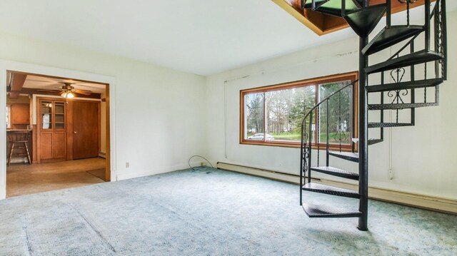 interior space with carpet flooring, baseboards, ceiling fan, and stairs