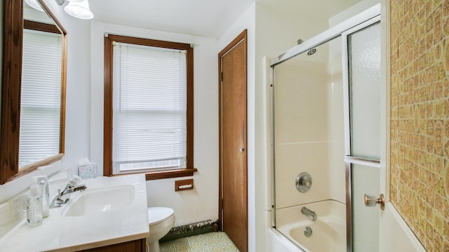 full bath with toilet, plenty of natural light, bath / shower combo with glass door, and vanity