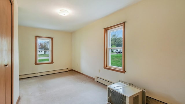 carpeted empty room with baseboards and a baseboard heating unit