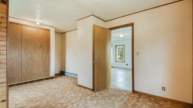 carpeted spare room featuring baseboards and a baseboard radiator