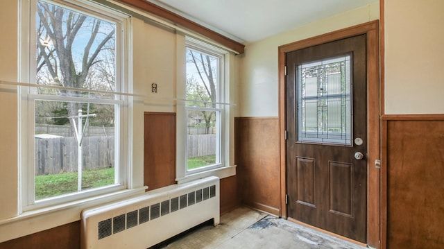 doorway featuring radiator and a wainscoted wall