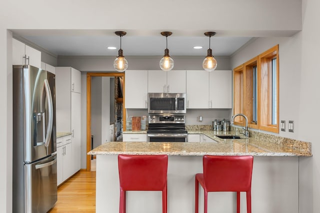 8440 Delaney Ct, Inver Grove Heights, MN 55076 - kitchen featuring stainless steel appliances, a sink, a peninsula, light wood-style flooring, and white cabinets