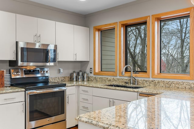 8440 Delaney Ct, Inver Grove Heights, MN 55076 - kitchen with stainless steel appliances, a sink, white cabinets, light stone counters, and ornamental molding