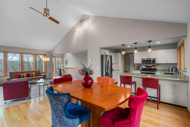 8440 Delaney Ct, Inver Grove Heights, MN 55076 - dining room with light wood-style flooring, ceiling fan, and high vaulted ceiling