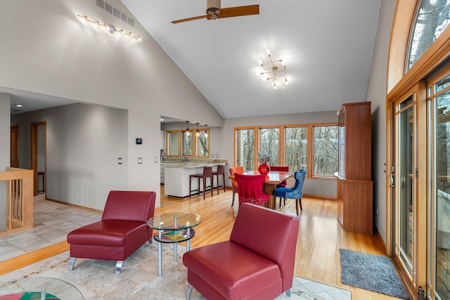 8440 Delaney Ct, Inver Grove Heights, MN 55076 - living room with high vaulted ceiling, a ceiling fan, light wood-style flooring, and baseboards