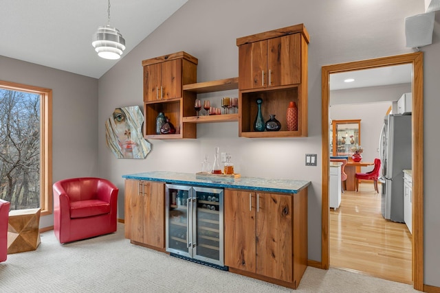 8440 Delaney Ct, Inver Grove Heights, MN 55076 - indoor dry bar with wine cooler, freestanding refrigerator, lofted ceiling, light carpet, and baseboards