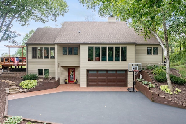 8440 Delaney Ct, Inver Grove Heights, MN 55076 - view of front of house with a garage, a chimney, asphalt driveway, a deck, and roof with shingles