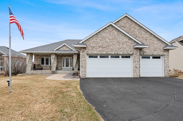 707 Bergman Ct NW, Isanti, MN 55040 - view of front of home with a front yard, brick siding, an attached garage, french doors, and driveway