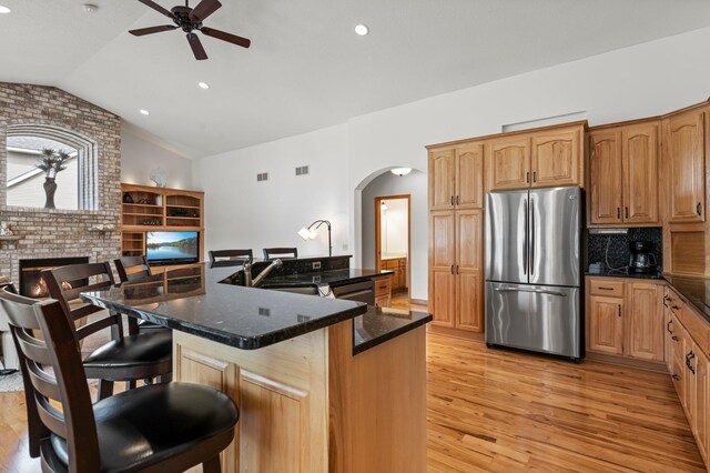 707 Bergman Ct NW, Isanti, MN 55040 - kitchen with freestanding refrigerator, arched walkways, a ceiling fan, vaulted ceiling, and light wood finished floors