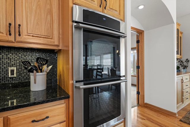 707 Bergman Ct NW, Isanti, MN 55040 - kitchen featuring recessed lighting, backsplash, stainless steel double oven, dark stone counters, and light wood finished floors