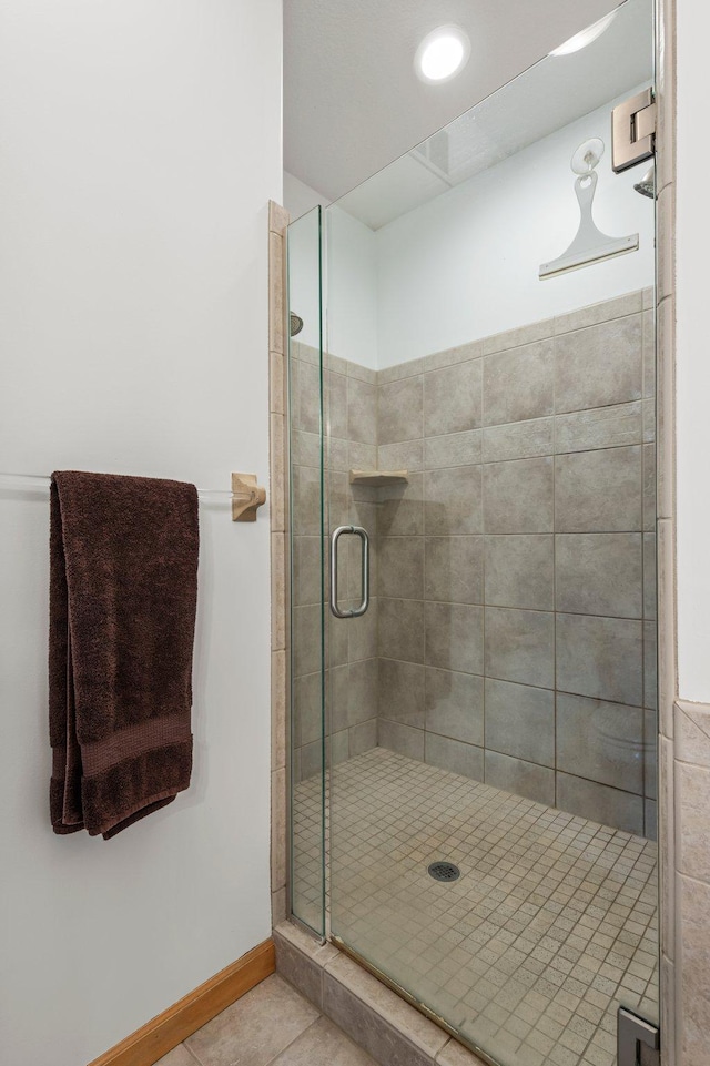 707 Bergman Ct NW, Isanti, MN 55040 - bathroom featuring a shower stall, baseboards, and tile patterned flooring
