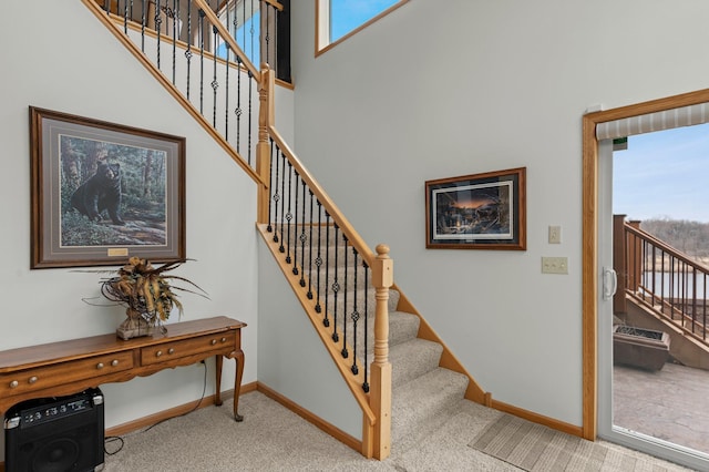 707 Bergman Ct NW, Isanti, MN 55040 - stairs featuring a healthy amount of sunlight, carpet flooring, baseboards, and a towering ceiling