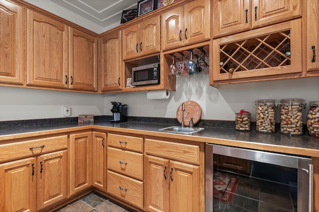 707 Bergman Ct NW, Isanti, MN 55040 - kitchen featuring brown cabinetry, stainless steel microwave, a sink, dark countertops, and wine cooler