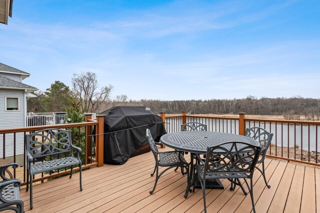 707 Bergman Ct NW, Isanti, MN 55040 - wooden deck with a wooded view, outdoor dining area, and area for grilling