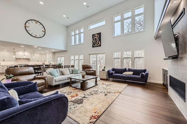 925 Minnesota Ln N, Plymouth, MN 55447 - living room featuring recessed lighting, a tile fireplace, a high ceiling, hardwood / wood-style floors, and baseboards