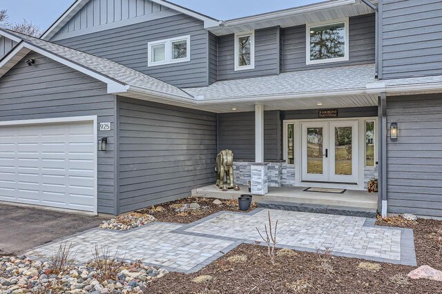 925 Minnesota Ln N, Plymouth, MN 55447 - view of exterior entry with board and batten siding, a shingled roof, covered porch, and french doors