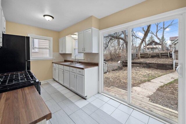 1119 6th St E, Saint Paul, MN 55106 - kitchen featuring black appliances, light tile patterned floors, a sink, and wooden counters