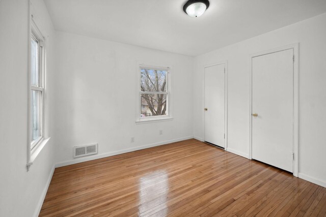 1119 6th St E, Saint Paul, MN 55106 - unfurnished bedroom featuring light wood finished floors, baseboards, and visible vents