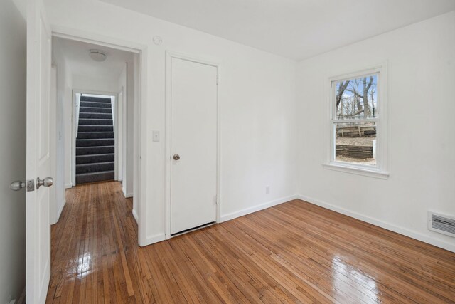 1119 6th St E, Saint Paul, MN 55106 - unfurnished bedroom with wood-type flooring, visible vents, and baseboards