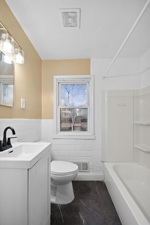 1119 6th St E, Saint Paul, MN 55106 - full bath with vanity, visible vents, tile walls, and toilet